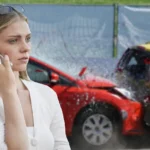 Auction buyer reviewing a vehicle history report beside a used sedan at an outdoor auction