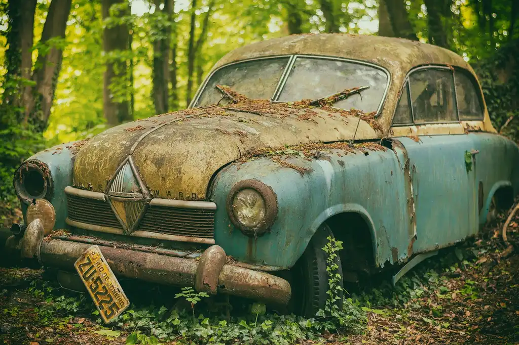 Car seller reviewing paperwork with an auction evaluator beside a sedan at an auction lot
