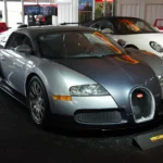 Dealer-only car auction lane with queued vehicles and buyers reviewing them outdoors