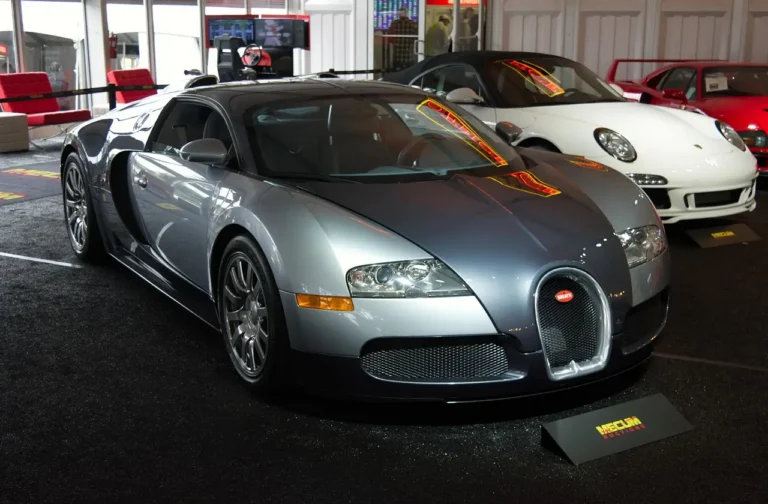 Dealer-only car auction lane with queued vehicles and buyers reviewing them outdoors